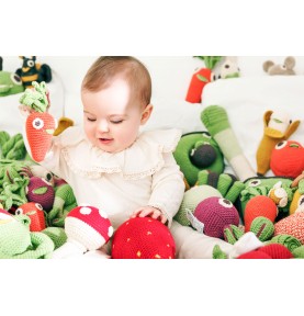 Bébé jouant avec hochets fruits et légumes en coton bio Veggy toys de la marque Myum