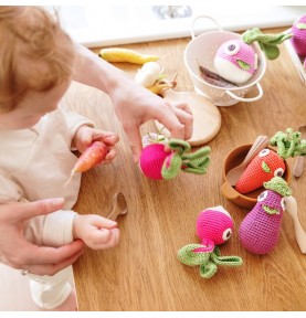 Enfant jouant avec hochets fruits et légumes Veggy Toys en coton bio signés Myum