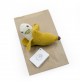 Barbara la Banane - hochet en coton bio de la collection Veggy Toys de la marque MyuM sur une feuille de papier