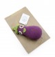 Régine l'Aubergine - hochet pour bébé en coton bio de la collection Veggy Toys de la marque MyuM, posé sur une feuille de papier