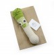 Orso le Poireau - hochet pour bébé en coton bio de la collection Veggy Toys de la marque MyuM, posé sur une feuille de papier